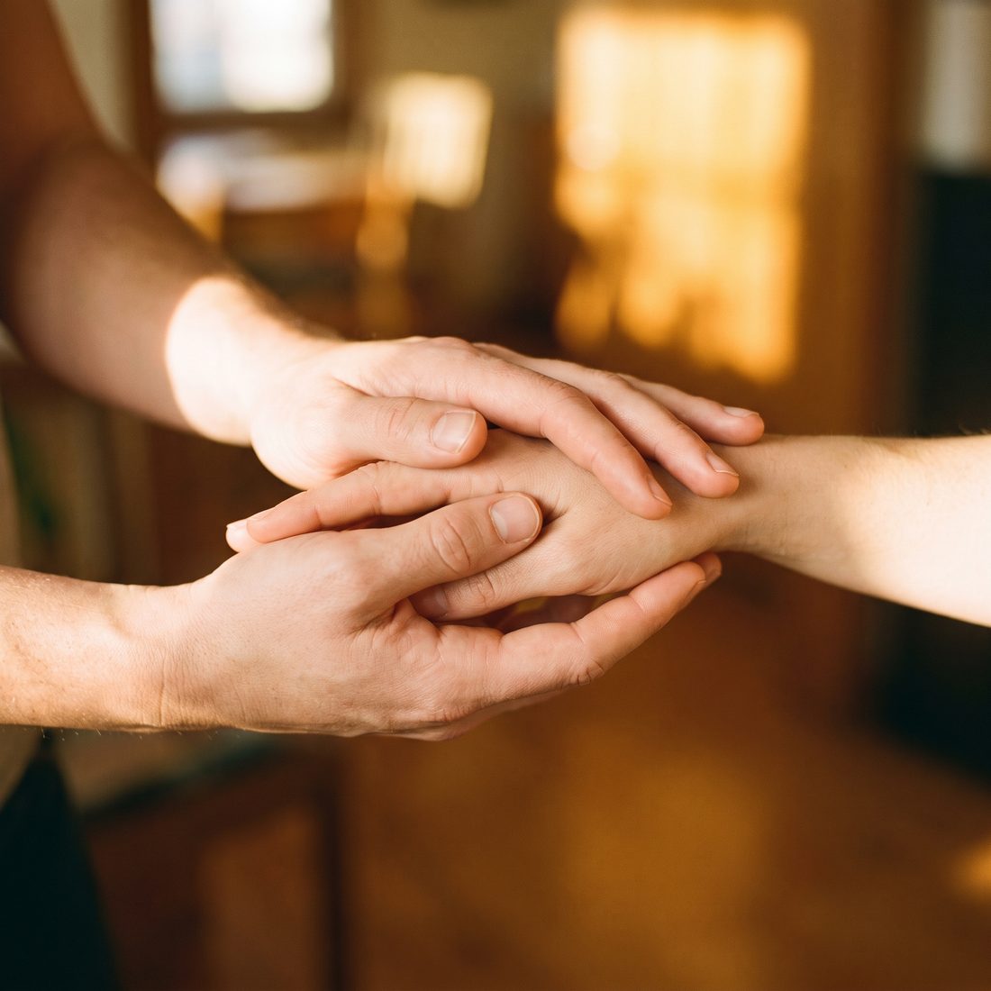 Zorgzame handen die iemand liefdevol ondersteunen.